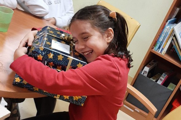 Kolping Wunschzettelaktion: Kind mit Weihnachtspäckchen