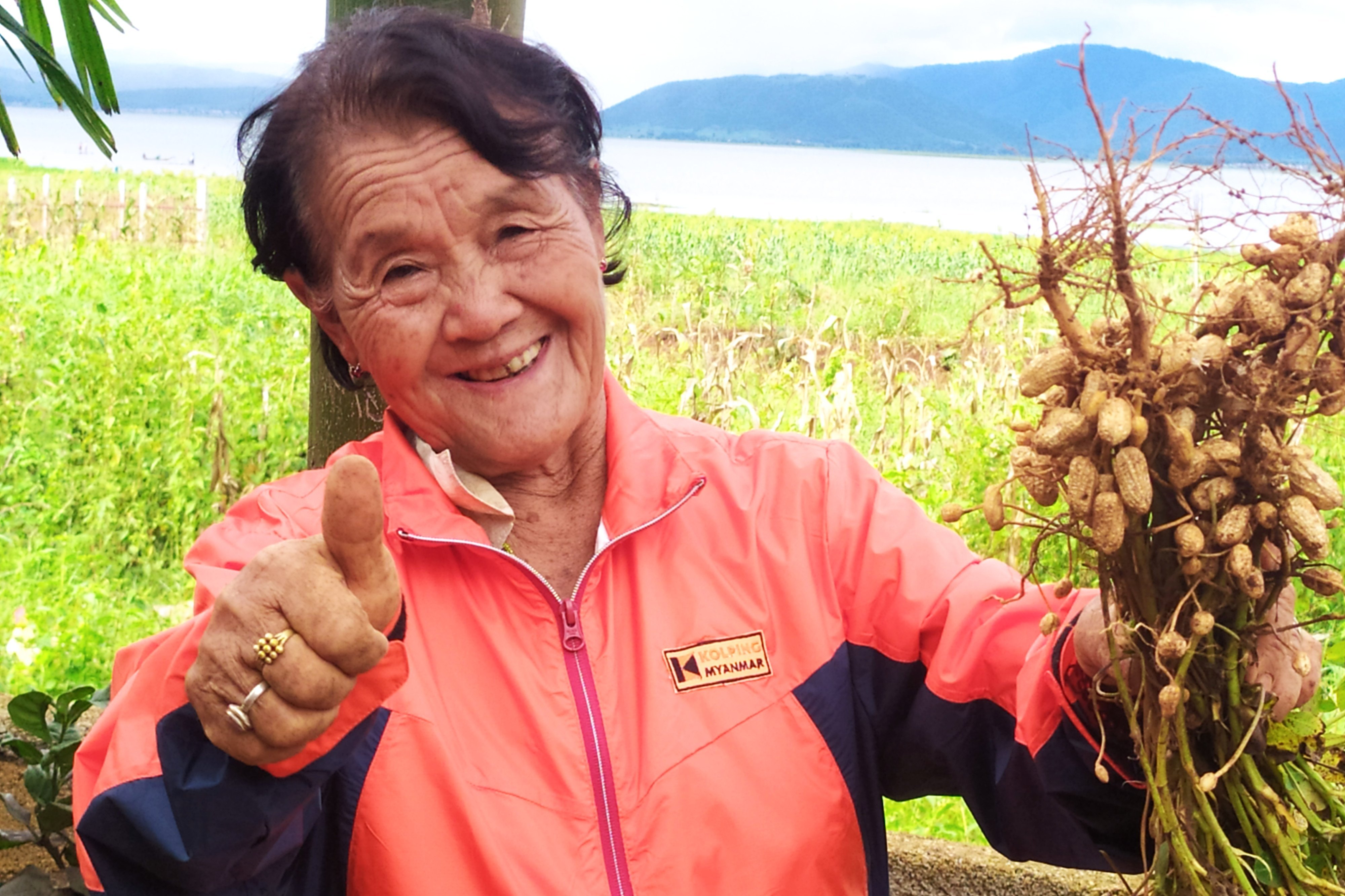 Frau die frisch geerntete Pflanzen in den Händen hält